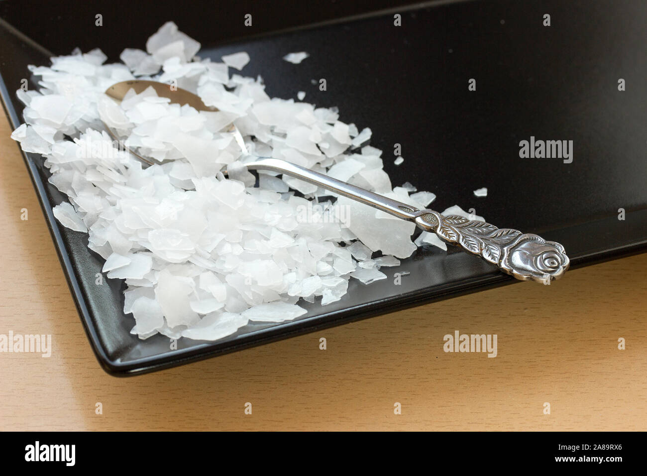 Magnesiumchlorid, Nigari Flocken auf einem dunklen Platte Stockfoto