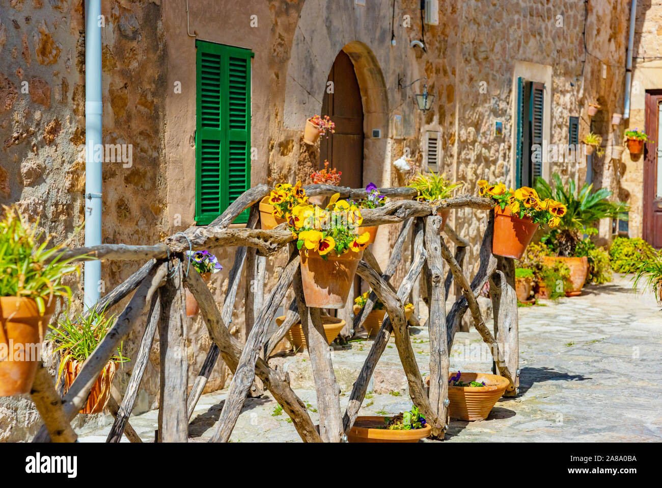 Schöne Fenster mit den Blumentöpfen und bunten Blumen als Dekoration der Fassade dienen. Spanisches Dorf Valldemossa, Mallorca, Balearen, Spanien Stockfoto