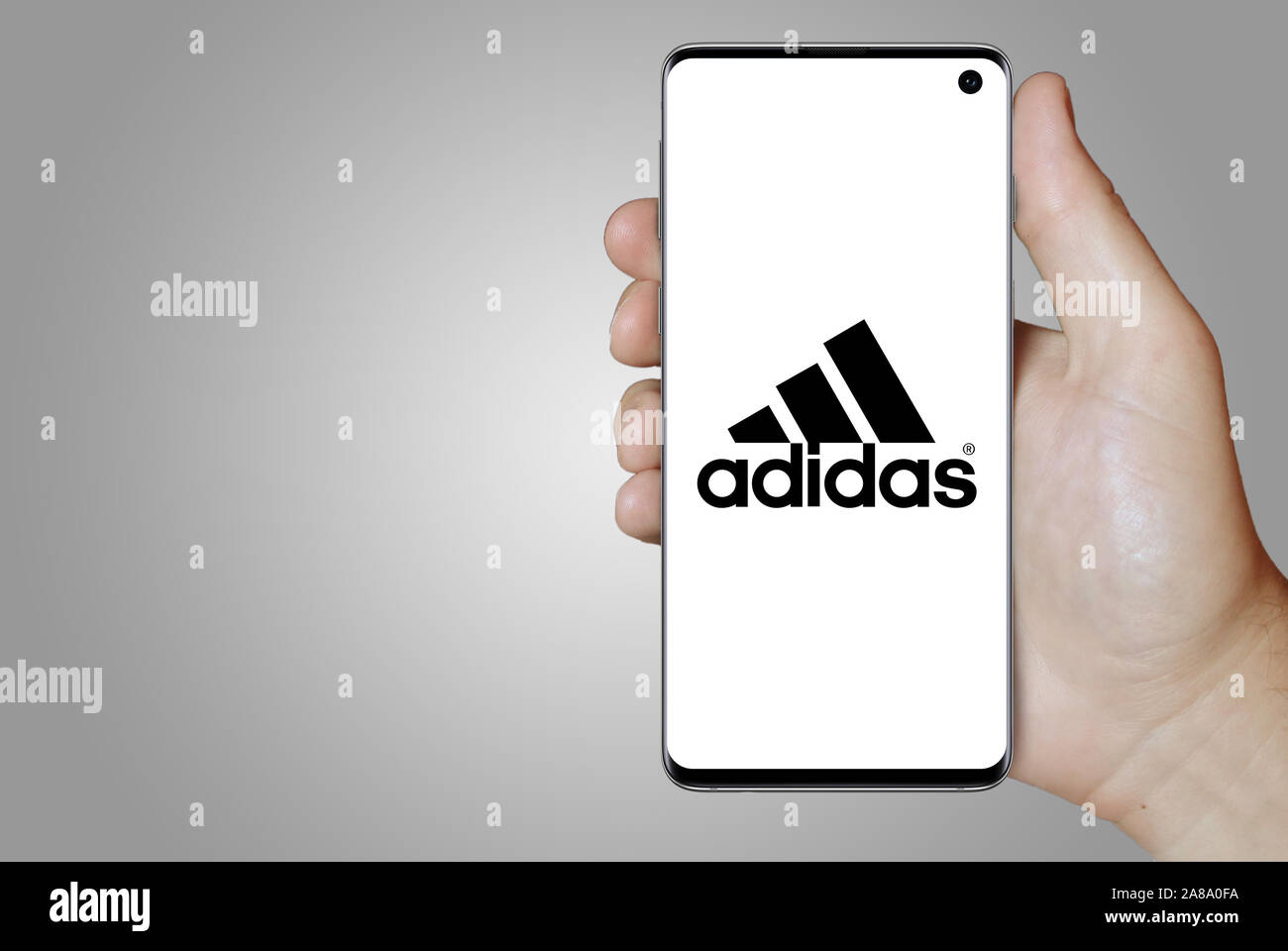 Logo der öffentlichen Unternehmen Adidas auf dem Smartphone angezeigt. Grauer Hintergrund. Credit: PIXDUCE Stockfoto