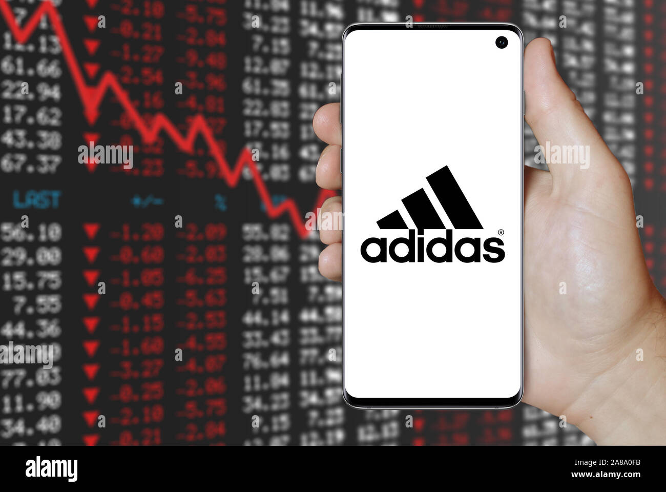 Logo der öffentlichen Unternehmen Adidas auf dem Smartphone angezeigt. Negative Börse Hintergrund. Credit: PIXDUCE Stockfoto