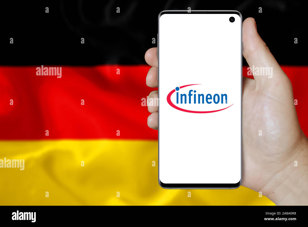 Logo der öffentlichen Unternehmen Infineon Technologies auf dem Smartphone angezeigt. Flagge Deutschland Hintergrund. Credit: PIXDUCE Stockfoto