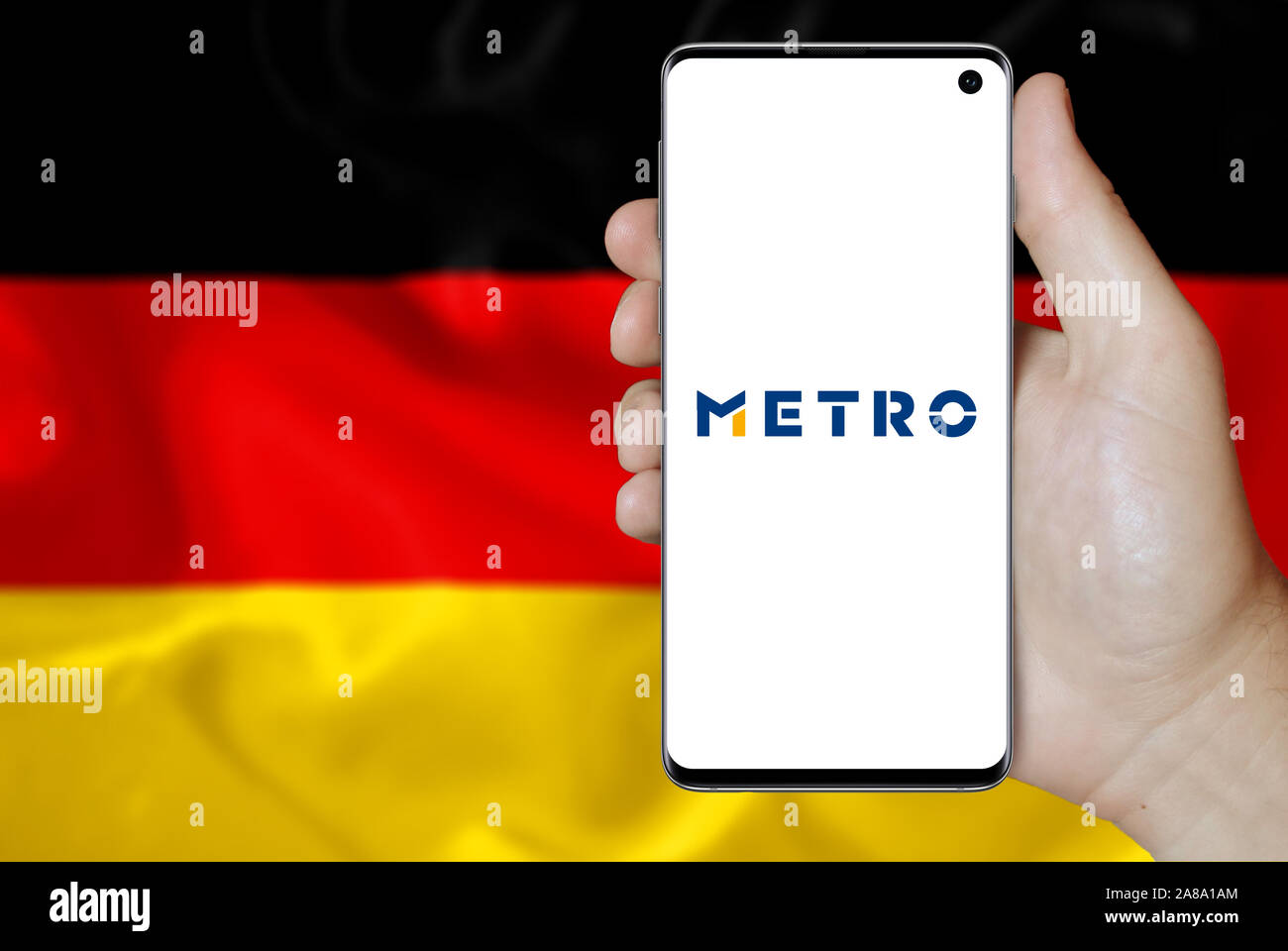 Logo der öffentlichen Unternehmen Metro AG auf dem Smartphone angezeigt. Flagge Deutschland Hintergrund. Credit: PIXDUCE Stockfoto