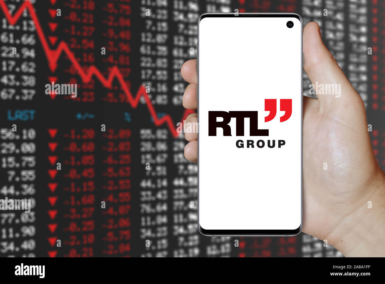Logo der öffentlichen Unternehmen RTL Group angezeigt auf einem Smartphone. Negative Börse Hintergrund. Credit: PIXDUCE Stockfoto