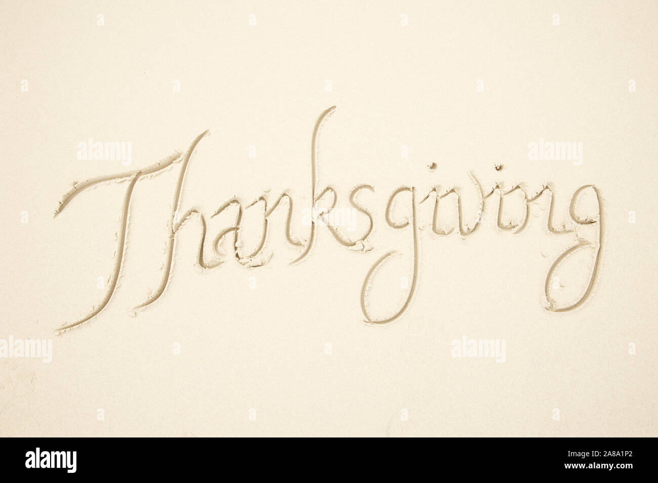 Einfache Thanksgiving reisen Nachricht handschriftlich in sorgfältigen Kalligraphie Skript auf glattem hellen Sandstrand Stockfoto