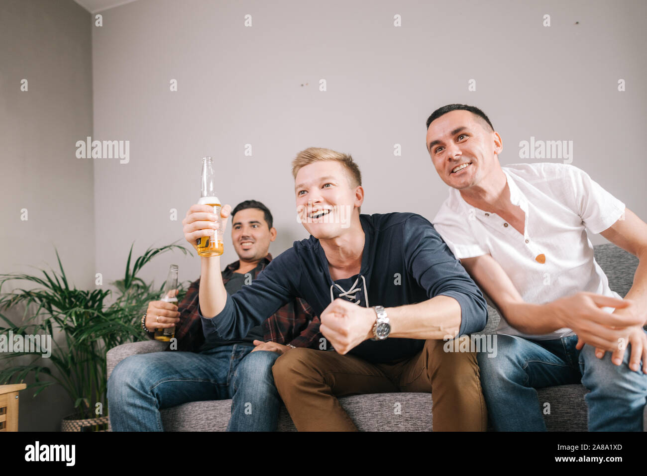 Gruppe von jungen Freunden beobachten Sport Spiel auf Fernsehen Stockfoto