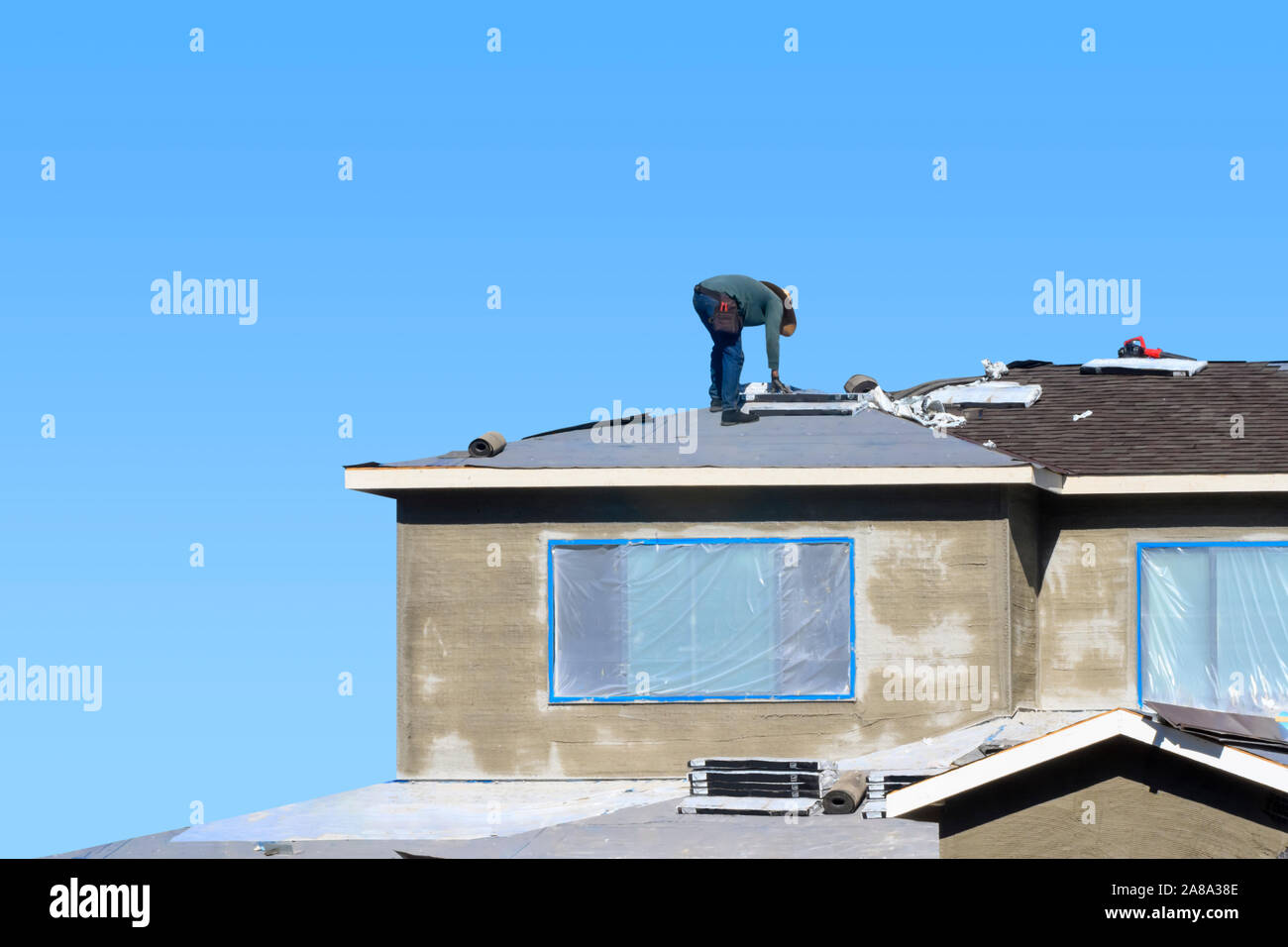Konzept des Bauprozesses. Qualifizierte Bauarbeiter, Asphalt Dachschindeln, der auf dem Dach eines neuen Hauses. Stockfoto