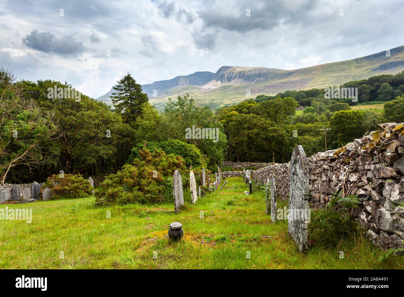 Die letzte Ruhestätte mit Aussicht. Der Cadair Idris Berge gesehen von einem alten Friedhof, Snowdonia National Park, Wales Stockfoto