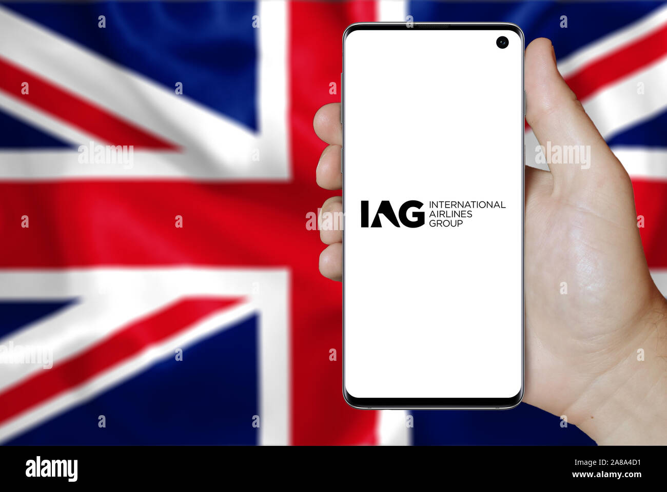 Logo der öffentlichen Unternehmen International Airlines Group angezeigt auf einem Smartphone. Flagge der Britischen Hintergrund. Credit: PIXDUCE Stockfoto