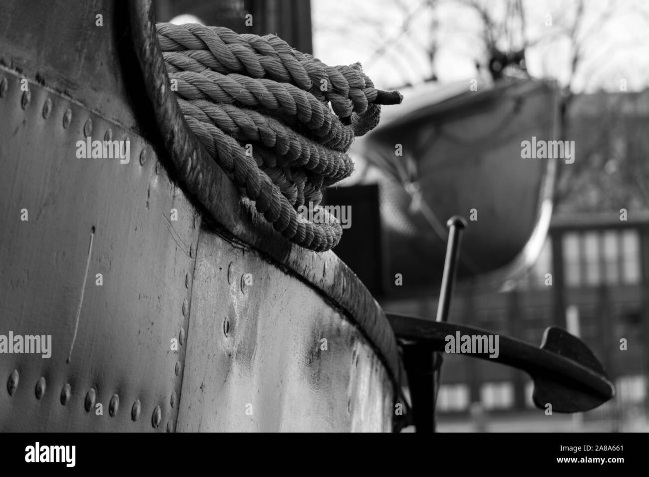 Schwarz-weiß Bild von der Nähe zu sehen, der ein altes Fischerboot, das Seil, Anker und Rettungsboot im Hintergrund, Stockholm - 2019 Stockfoto