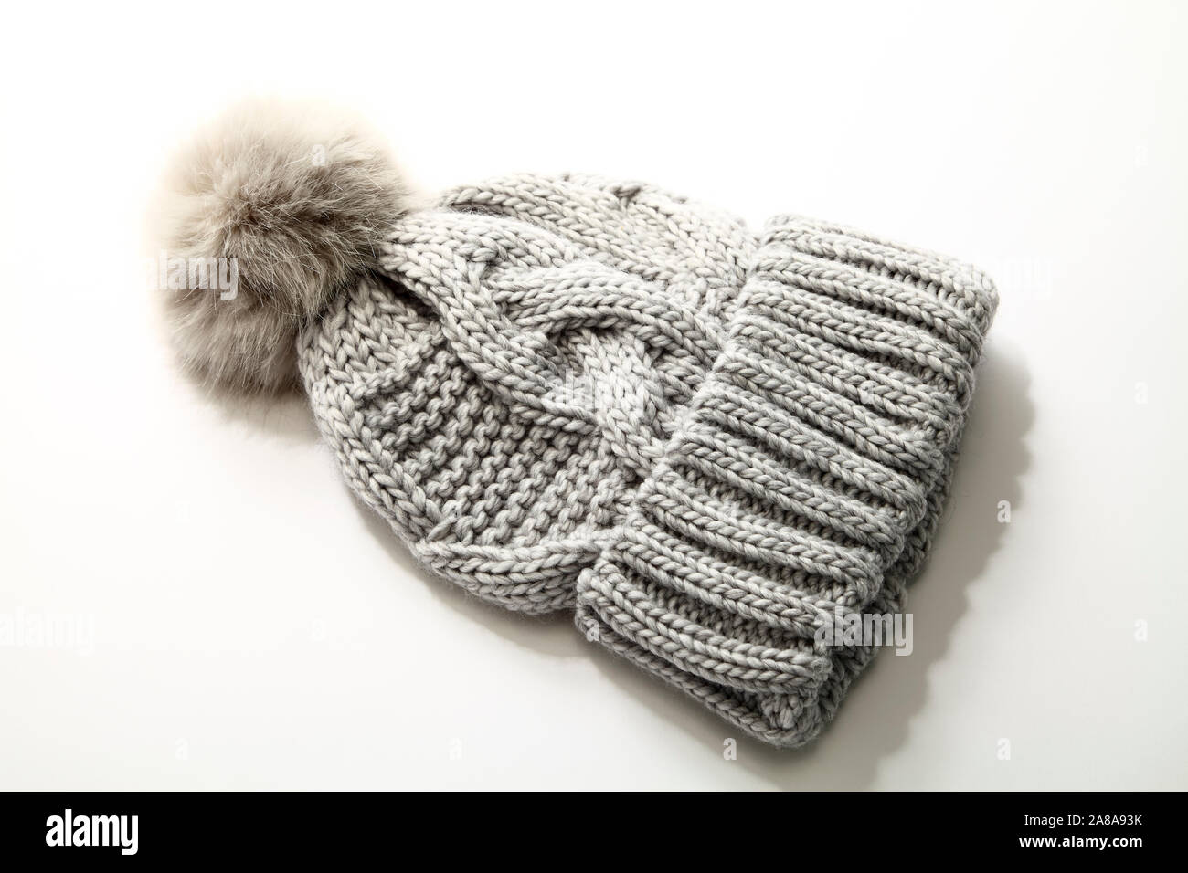 Grauen Winter warm bobble Hut mit pom pom auf weißem Hintergrund Stockfoto