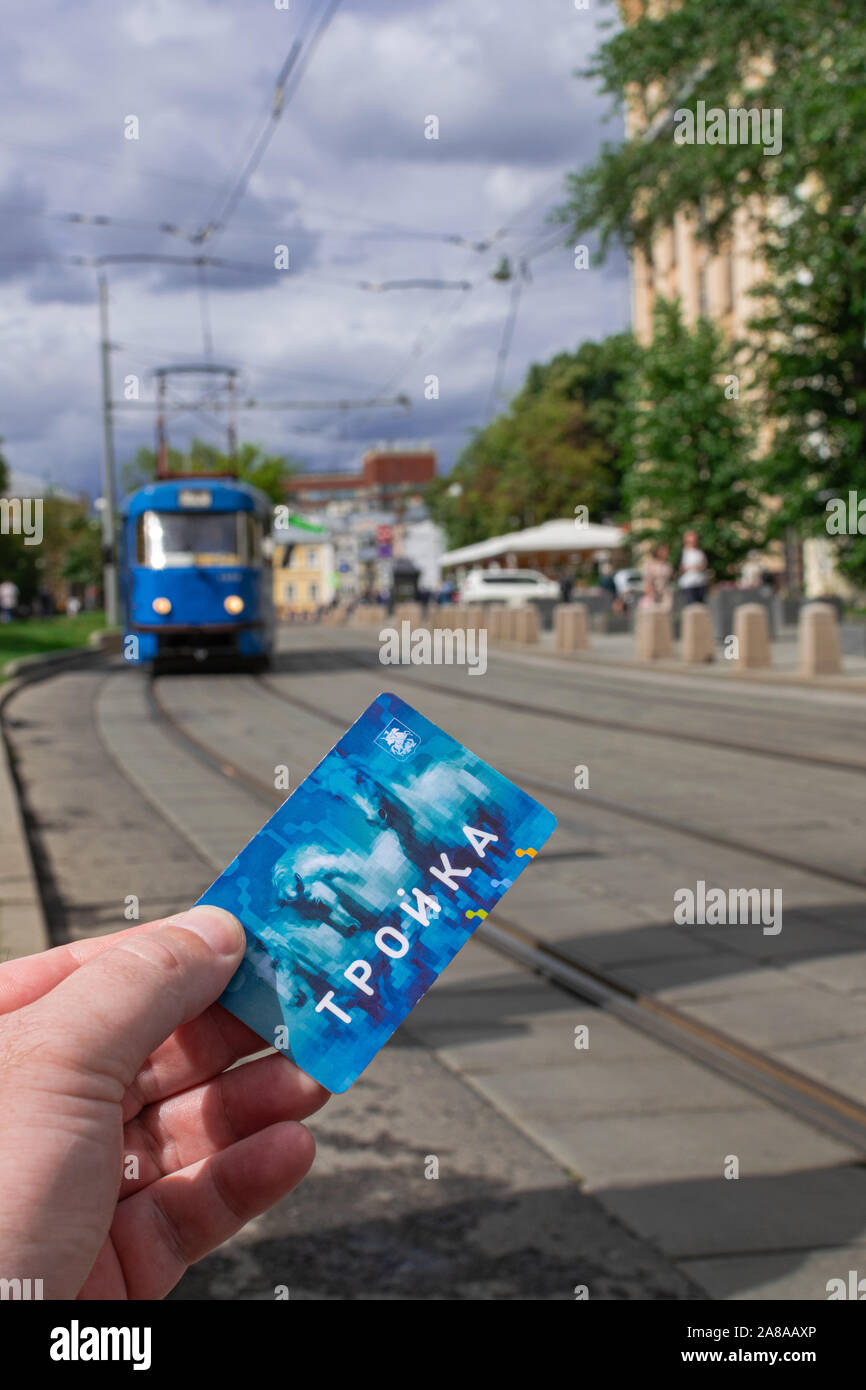 Moskau/Russland; 3. Juli 2019: Moskau Troika transport Card auf der linken, blauen elektrische Straßenbahn Hintergrund Stockfoto
