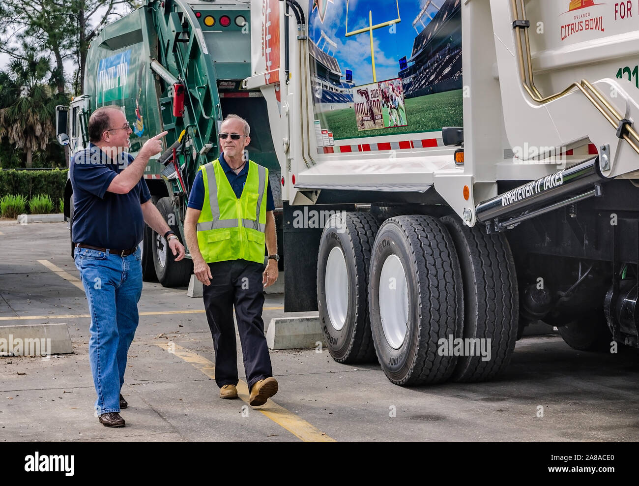 Tim Dolan, Abfall pro Regional Vice President für Central Florida, unterstreicht eine neue Lkw-wrap zu Operations Manager Terry Grady in Sanford, Florida. Stockfoto