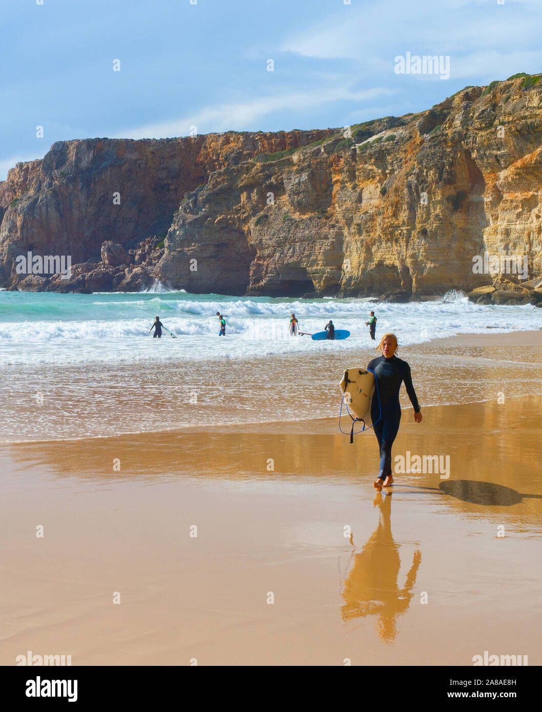 SAGRES, PORTUGAL - Oktober 30, 2018: Junger Mann zu Fuß vom Sandstrand mit Surfbrett. Die ALgarve ist eine berühmte Surfen in Portugal Stockfoto