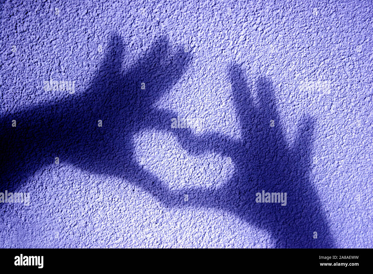 Schattenspiel, Schatten zweier Hände formen ein Herz in eine Mauer, Stockfoto