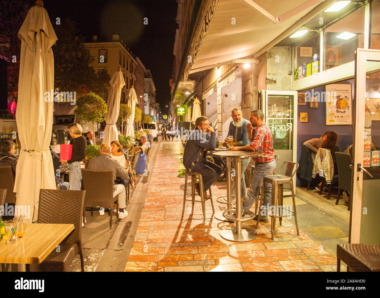 Die Menschen Essen und Trinken zu einem Cafe Restaurant am Abend der Nacht in der französischen Stadt Carcassonne Frankreich Stockfoto