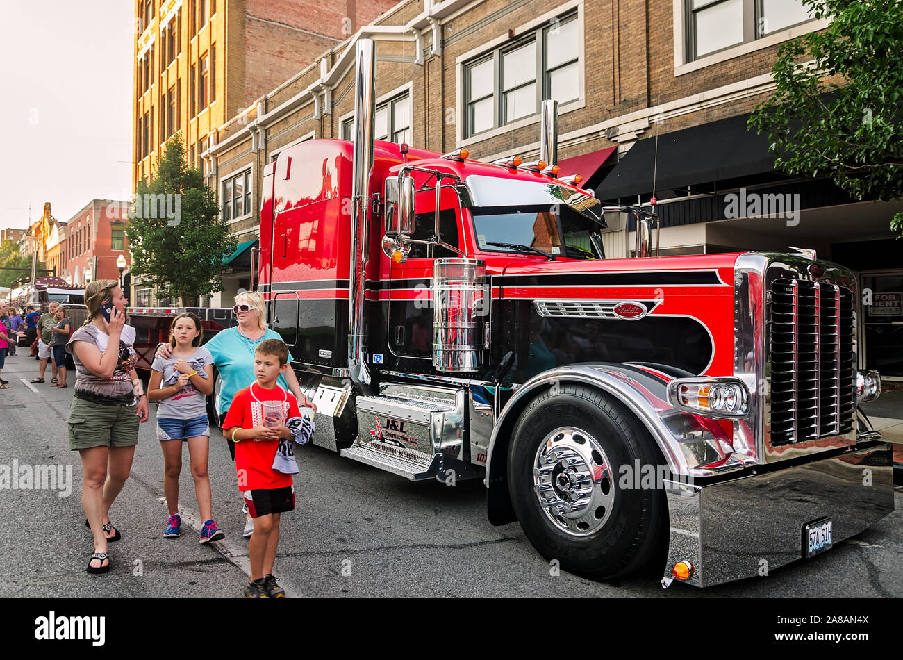 Big Rig Enthusiasten Spaziergang, vorbei an einem 2015 Peterbilt 389 Stolz & Klasse mit 2015 Etnyre Anhänger an der SuperRigs Truck Show in Joplin, Missouri. Stockfoto