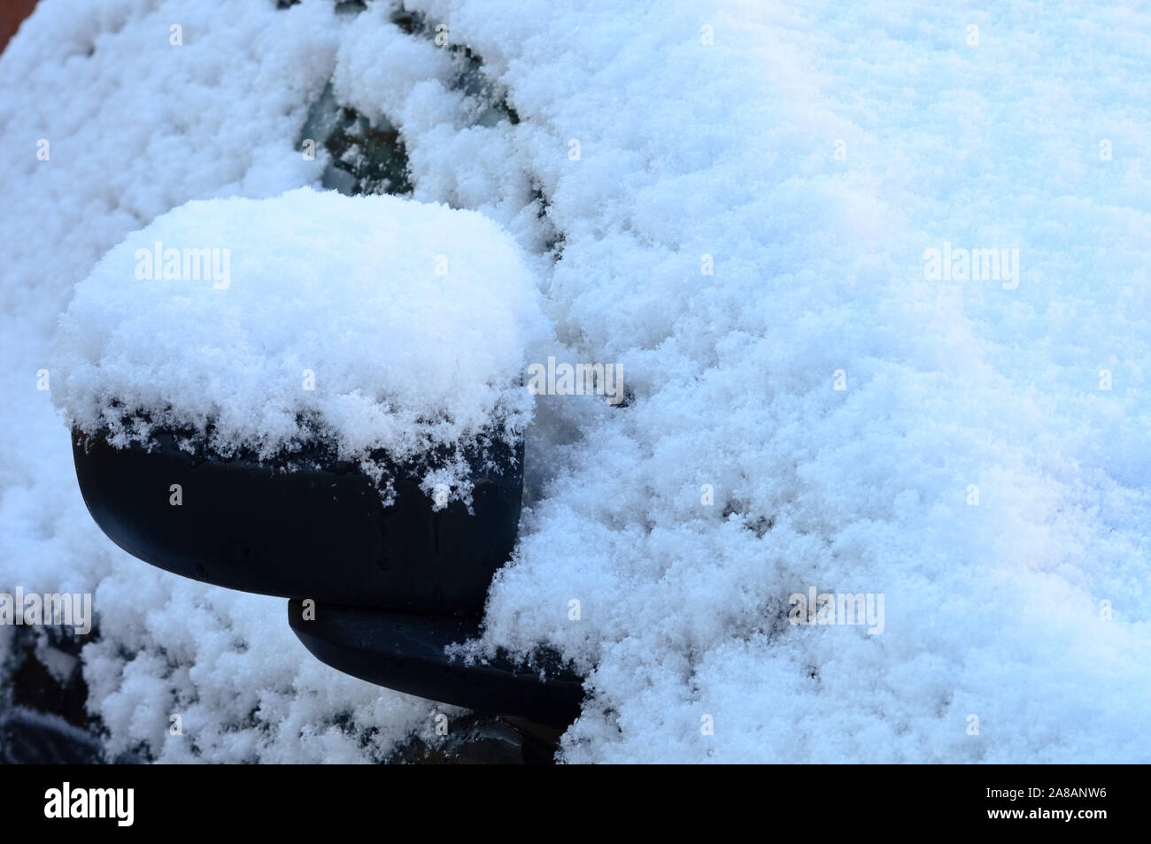 Außenspiegel und ein Auto mit weißen Schnee nach einem Schneefall, extreme Wetterbedingungen einen Unterschied machen können, in dem Sie unterwegs sind. Stockfoto