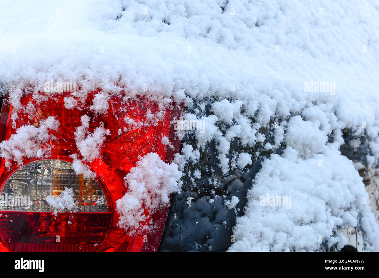 Auto rote Schlussleuchte unter Schnee nach einem Schneefall in einem frostigen Wintertag, schlechtes Wetter für das Fahren Stockfoto