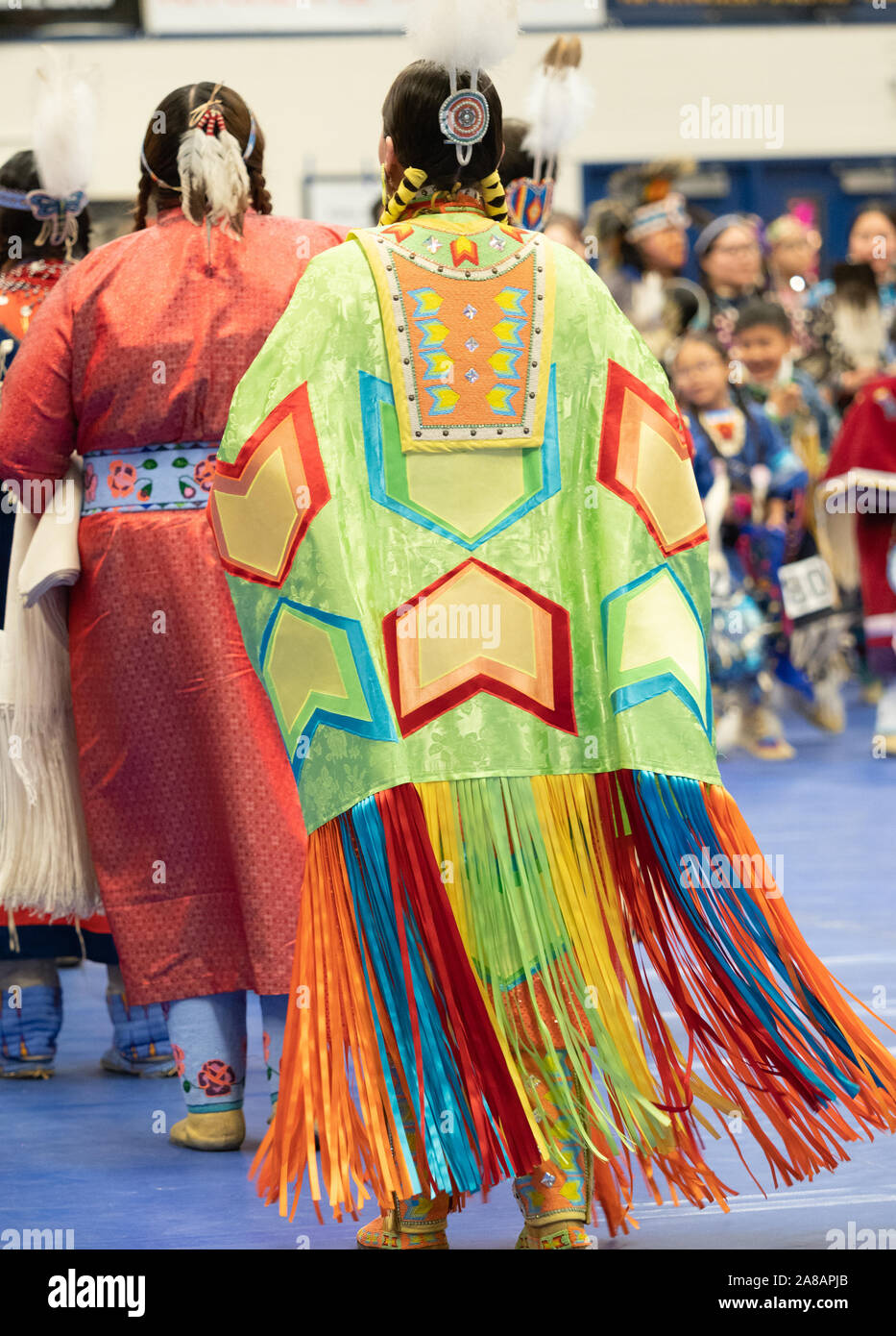 Native American Frau mit bunten Farbband Schal tanzen in einem Pow Wow mit dem Rücken zur Kamera. Stockfoto