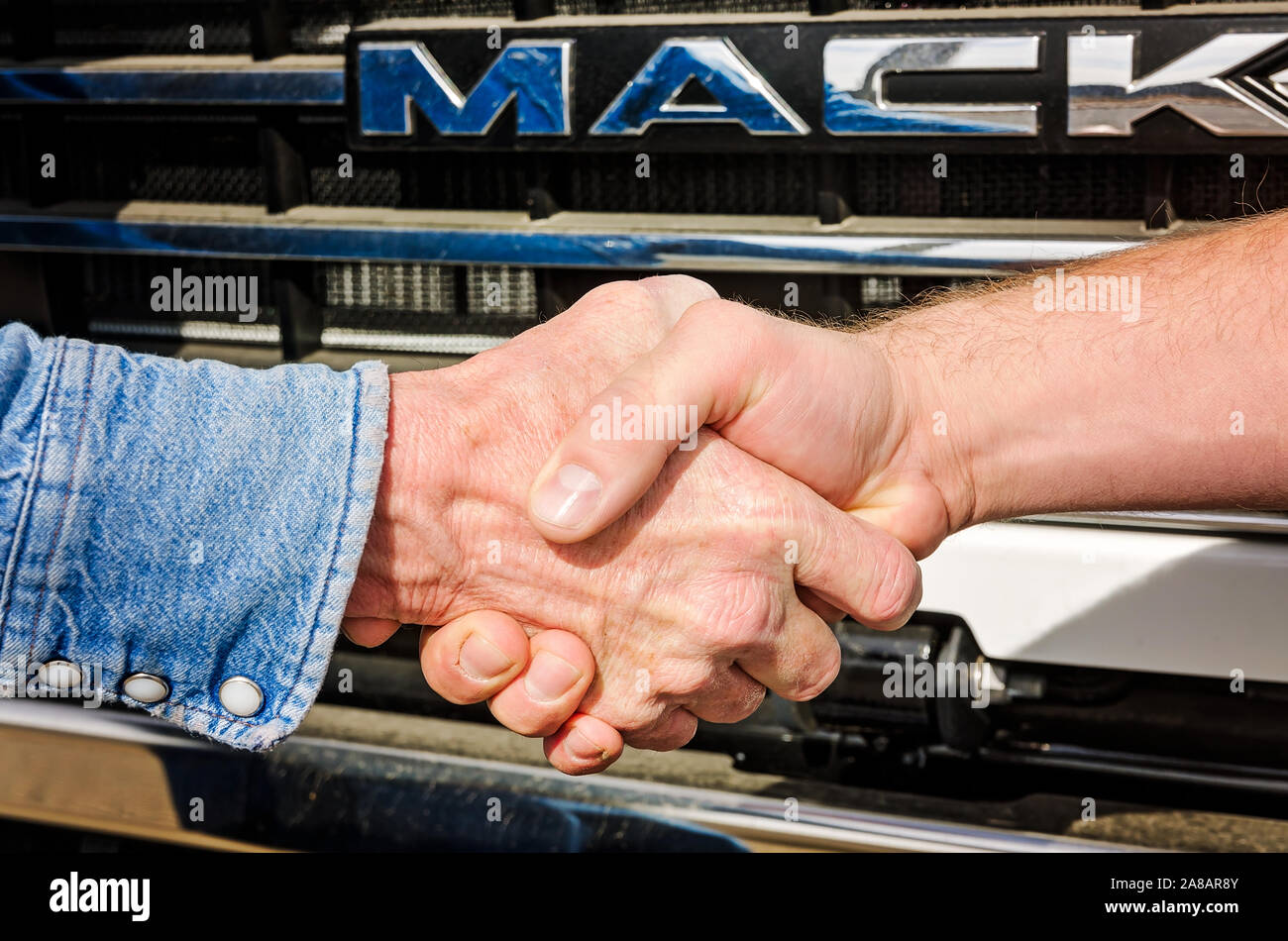 Ein Mack Trucks Service Manager schüttelt Hände mit einem Kunden an Bruckner Lkw, November 15, 2017 in Farmington, New Mexico. Stockfoto