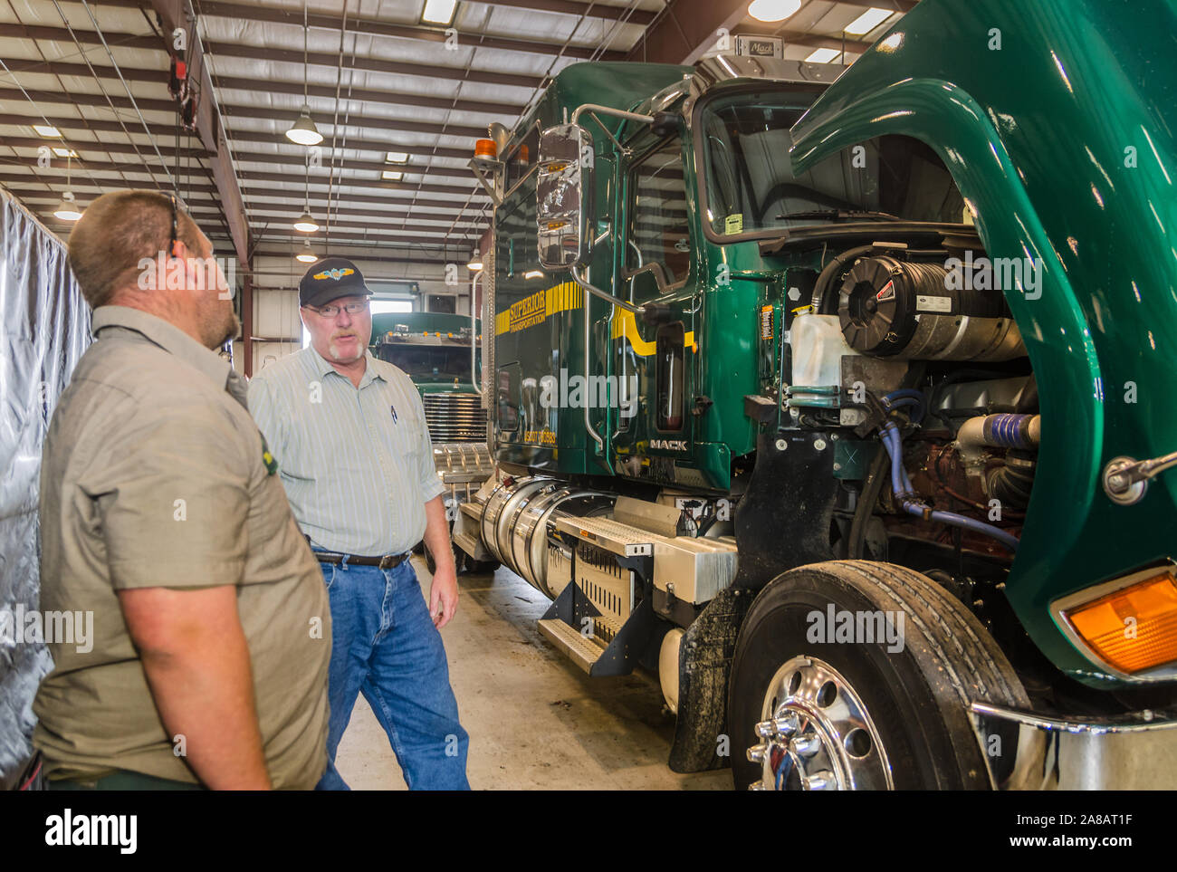 Eine überlegene Transport Techniker mit einem Sicherheit Direktor als Mack Pinnacle Lkw sitzt in der mechanischen Werkstatt in Superior Transport. Stockfoto