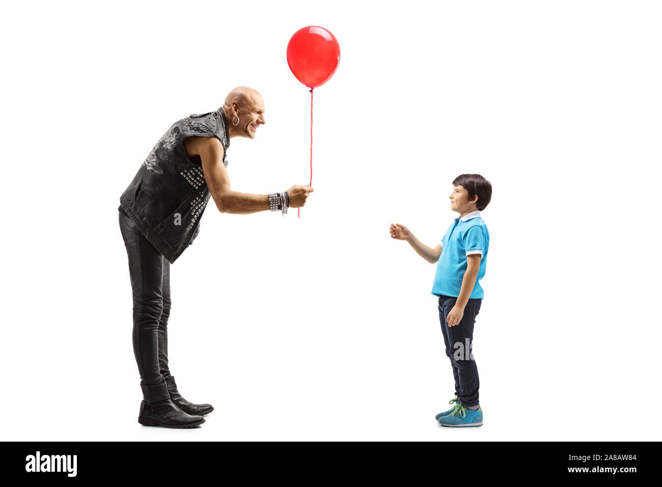Volle Länge Schuß eines Punkers in Leder Kleidung geben einen roten Ballon zu einem Kind auf weißem Hintergrund Stockfoto