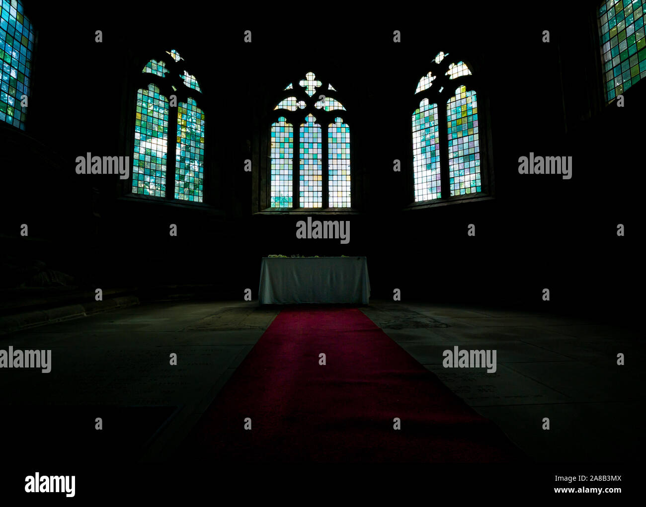 Gewölbte Kirchenfenster Aufleuchten roter Teppich in eine stimmungsvolle Atmosphäre, Seton College Kapelle, Kirche aus dem 16. Jahrhundert, East Lothian, Schottland, Großbritannien Stockfoto