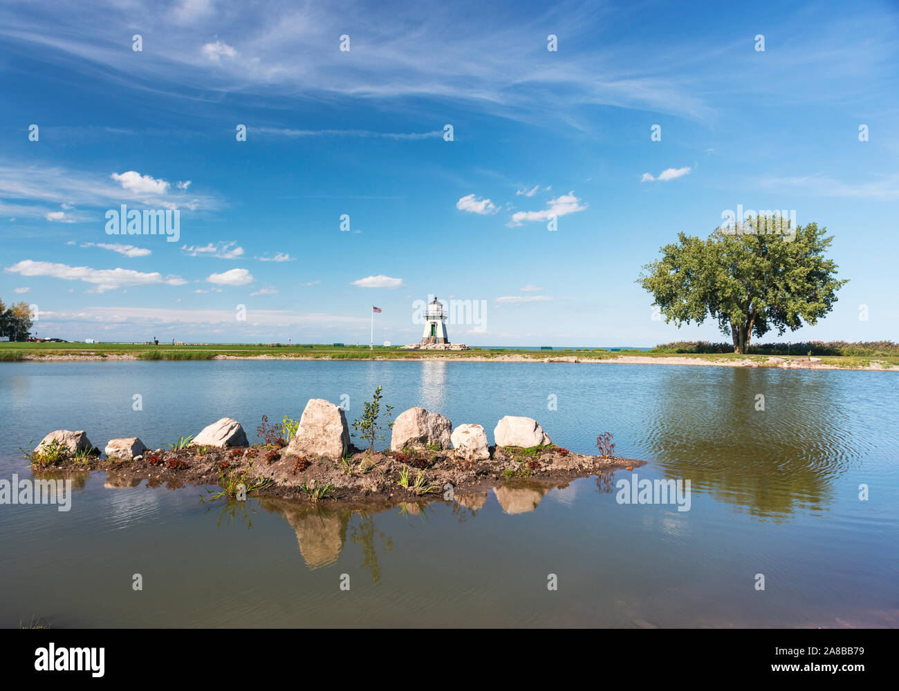 Port Clinton Light Station, Port Clinton, Ohio. Große Seen Leuchtturm Lake Erie dahinter steckt, über einen kleinen Teich in der Nähe getroffen. Siehe mehr Infos Stockfoto