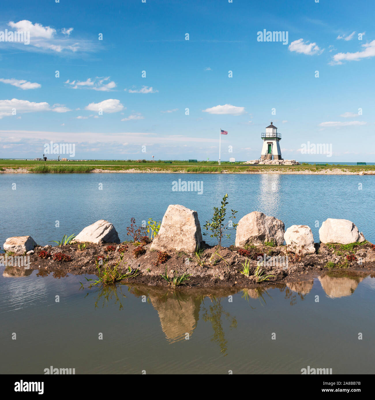 Port Clinton Light Station, Port Clinton, Ohio. Große Seen Leuchtturm Lake Erie dahinter steckt, über einen kleinen Teich in der Nähe getroffen. Siehe mehr Infos Stockfoto