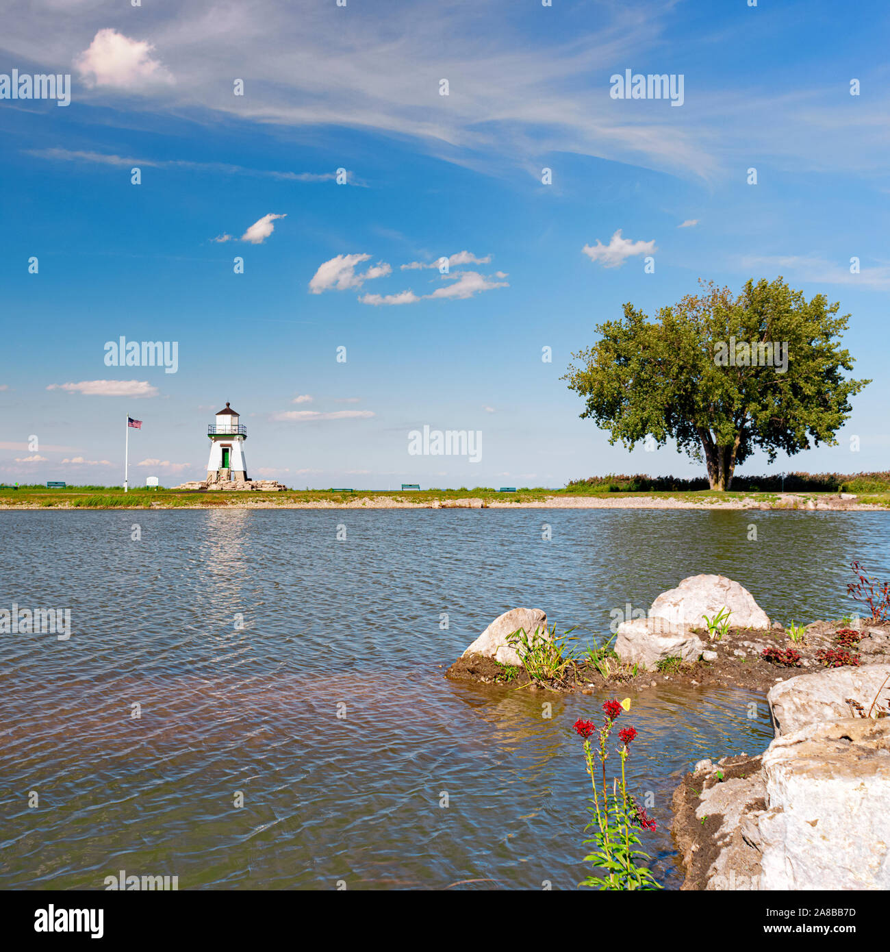 Port Clinton Light Station, Port Clinton, Ohio. Große Seen Leuchtturm Lake Erie dahinter steckt, über einen kleinen Teich in der Nähe getroffen. Siehe mehr Infos Stockfoto