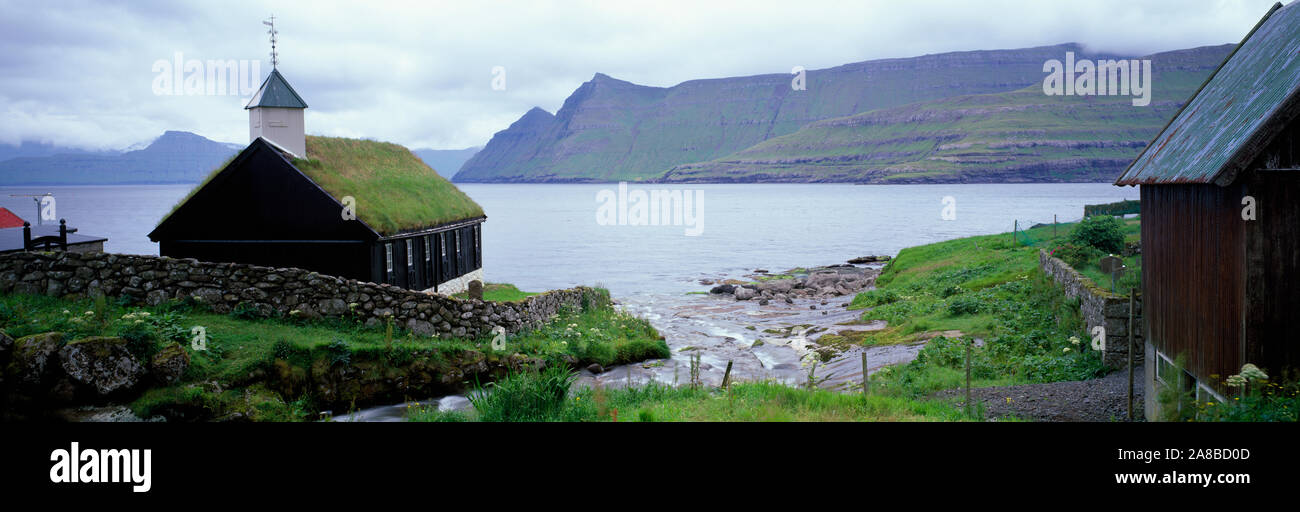 Blick auf Kirche mit Grasdach und den See im Hintergrund, Färöer Inseln Stockfoto