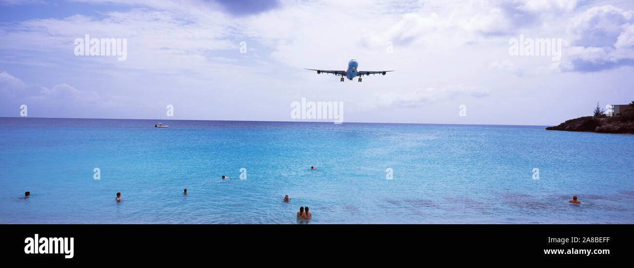 Flugzeug über das Meer fliegen, Maho Beach, Sint Maarten, Niederländische Antillen Stockfoto