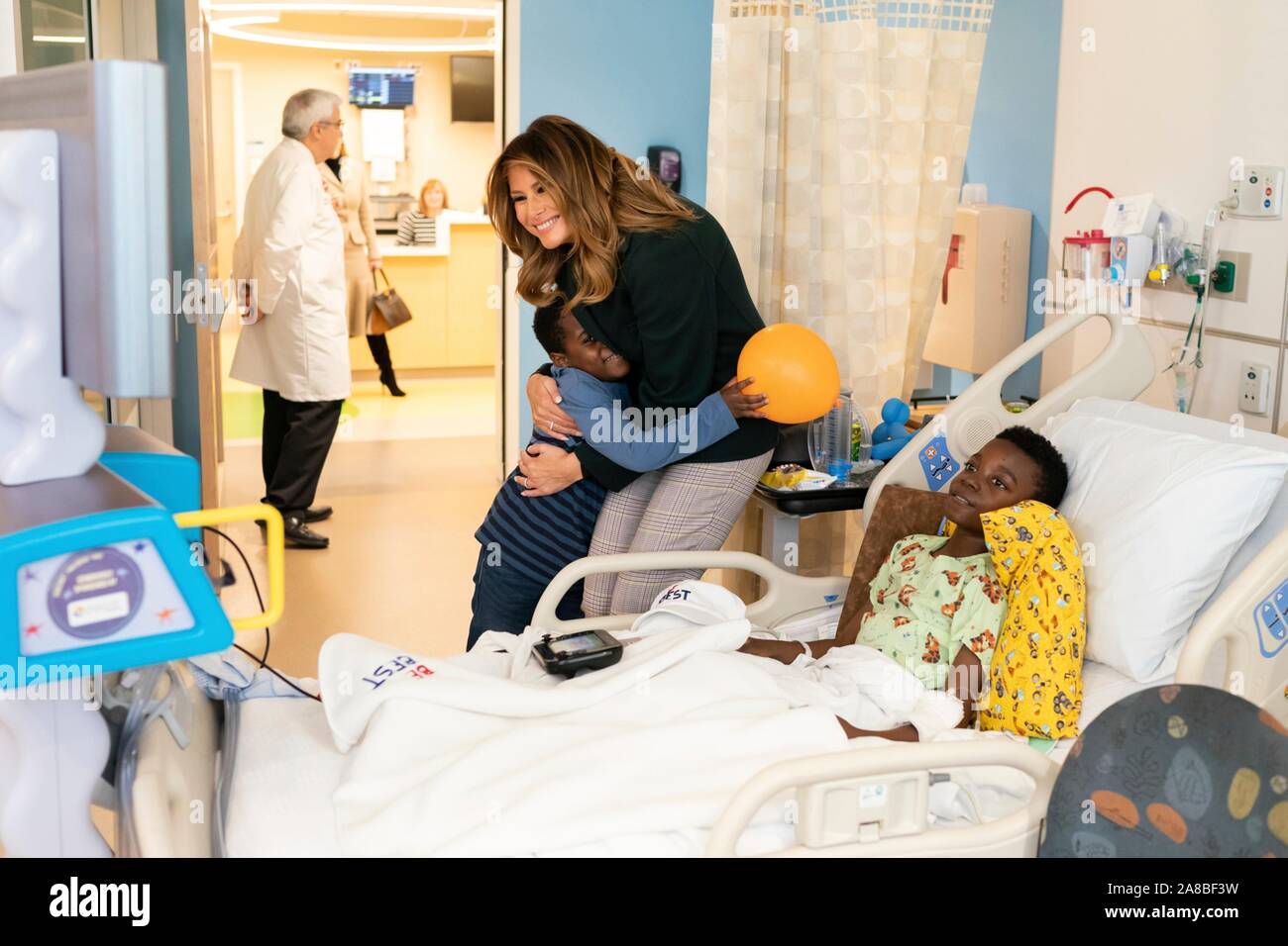 Us-First Lady Melania Trump ist umarmt von einer Jungen, als sie Geschenke an Patienten und Familienmitglieder verteilt während einer Tour von der Kinderklinik in Boston Medical Center November 6, 2019 in Boston, Massachusetts. Stockfoto