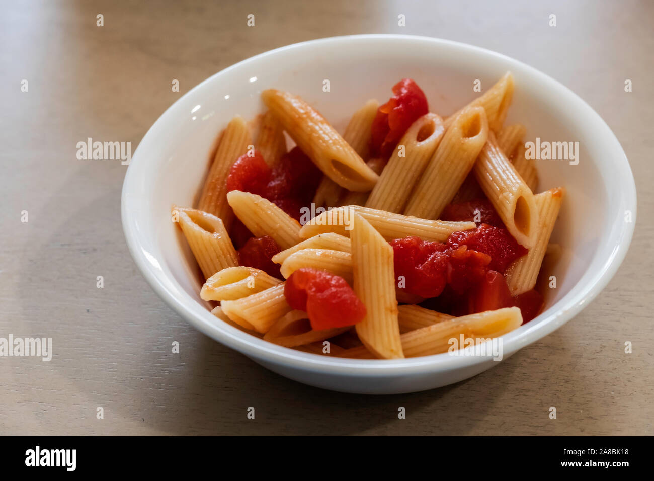 Gekochte Nudeln und Tomaten in einer kleinen weißen Schale. Stockfoto