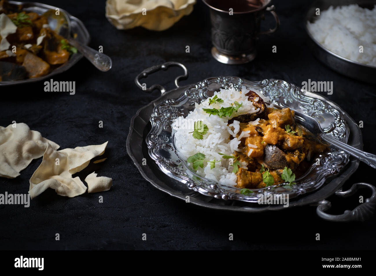 Im indischen Stil Auberginen in korma Sauce und Reis auf dunklem Hintergrund Stockfoto