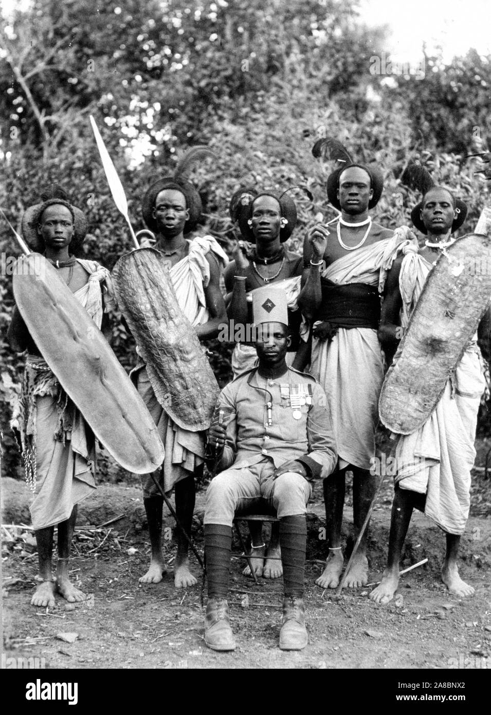 Foto zeigt eine Gruppe von SUDANESISCHEN (vielleicht aus dem Sudan) Krieger steht neben einer sitzenden Offizier Stockfoto