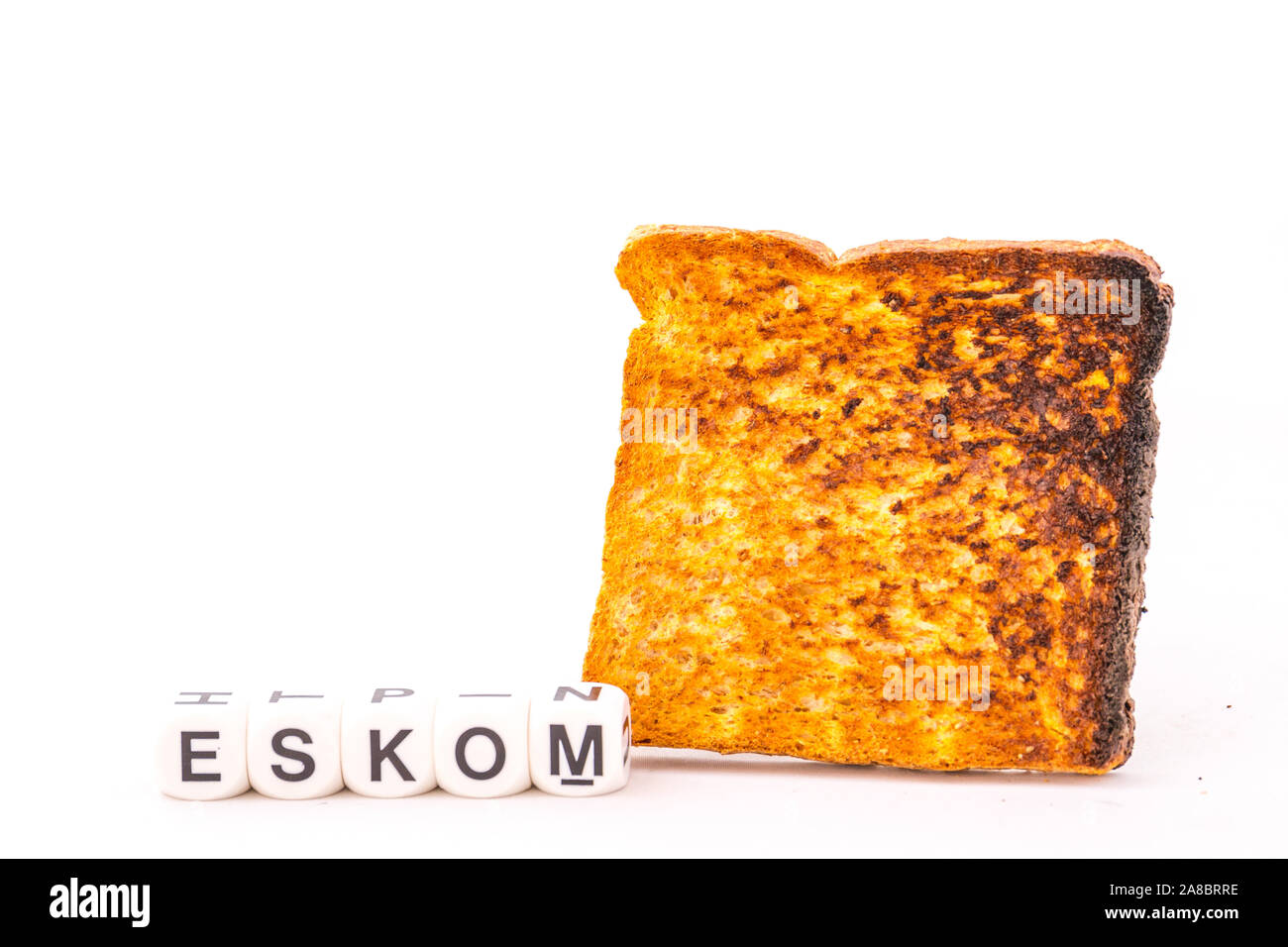 Energieversorger Eskom in Südafrika und ein Stück der verbrannten Toast auf einem weißen Hintergrund Bild mit Kopie Raum im Querformat isoliert Stockfoto
