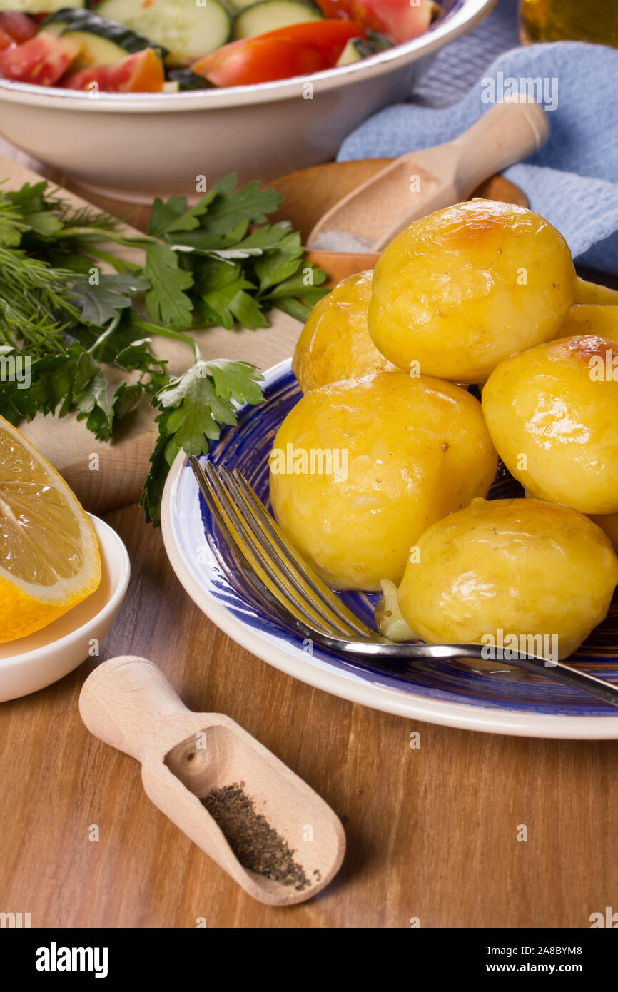 Frittierte Kartoffeln und Salat auf dem Küchentisch Stockfoto