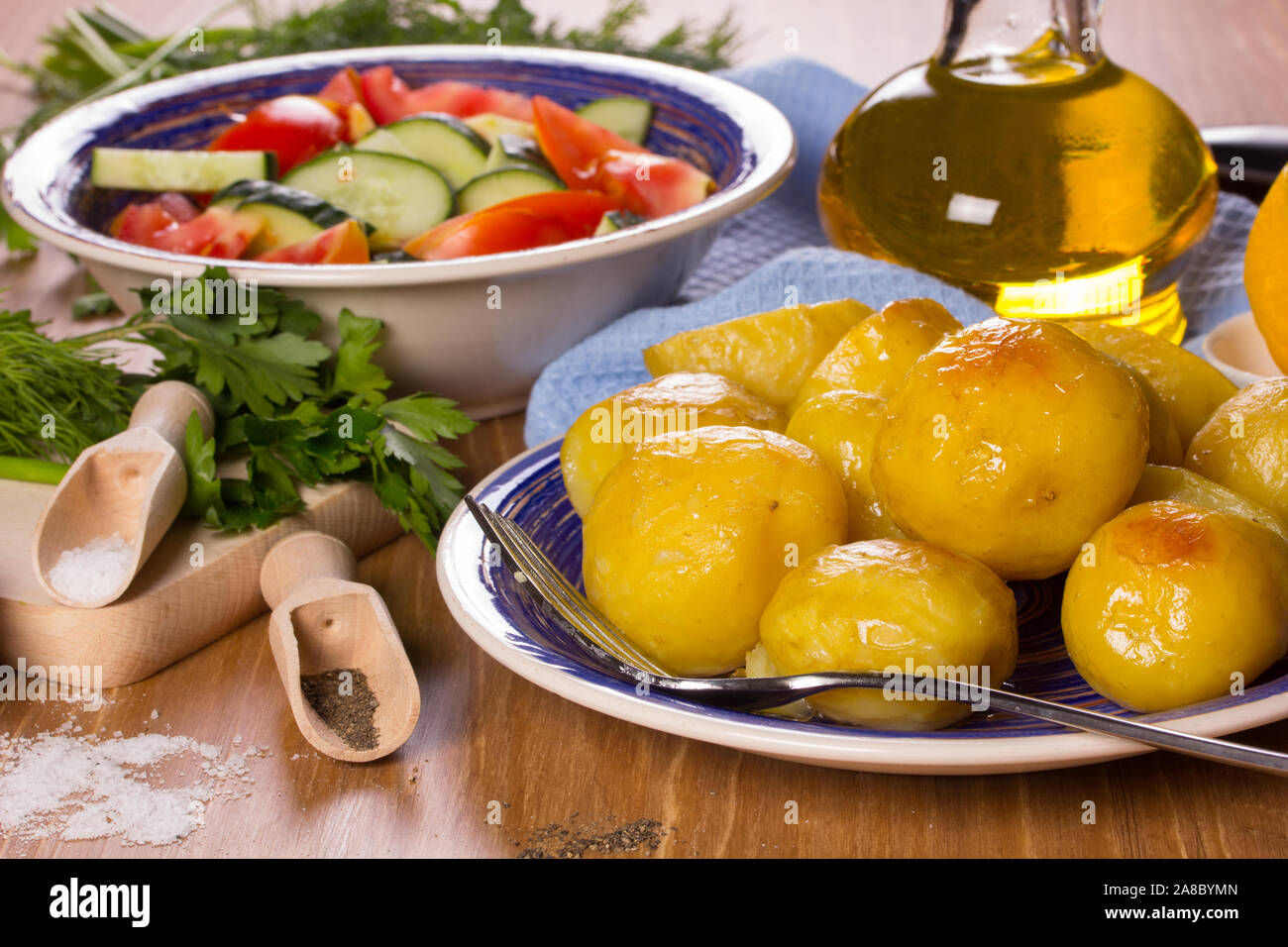 Frittierte Kartoffeln, Salat, Pflanzenöl auf dem Küchentisch Stockfoto