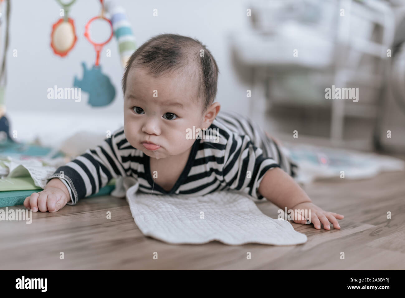 Adorable Asiatischen baby boy Lernen zu krabbeln und Spielen auf dem Boden zu Hause. Kind ist 5 Monate alt. Stockfoto