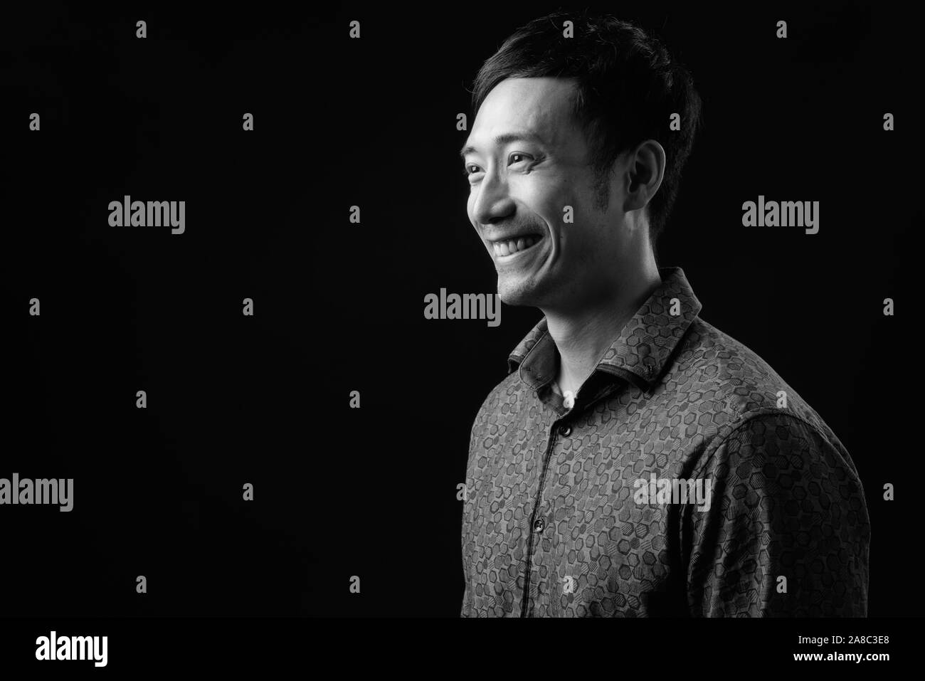 Junge hübsche Asiatische Geschäftsmann auf schwarzem Hintergrund Stockfoto