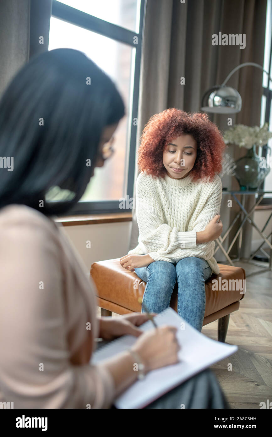 Curly Frau besser Gefühl beim Gespräch mit dem Psychoanalytiker Stockfoto