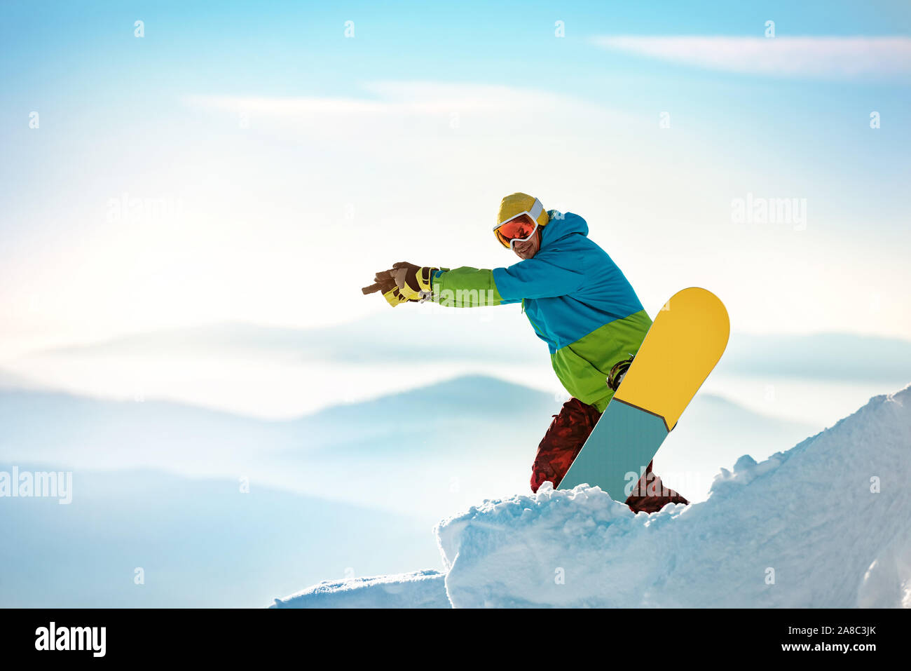 Snowboarder steht mit dem Snowboard auf der Piste und auf etwas. Platz für Text Stockfoto