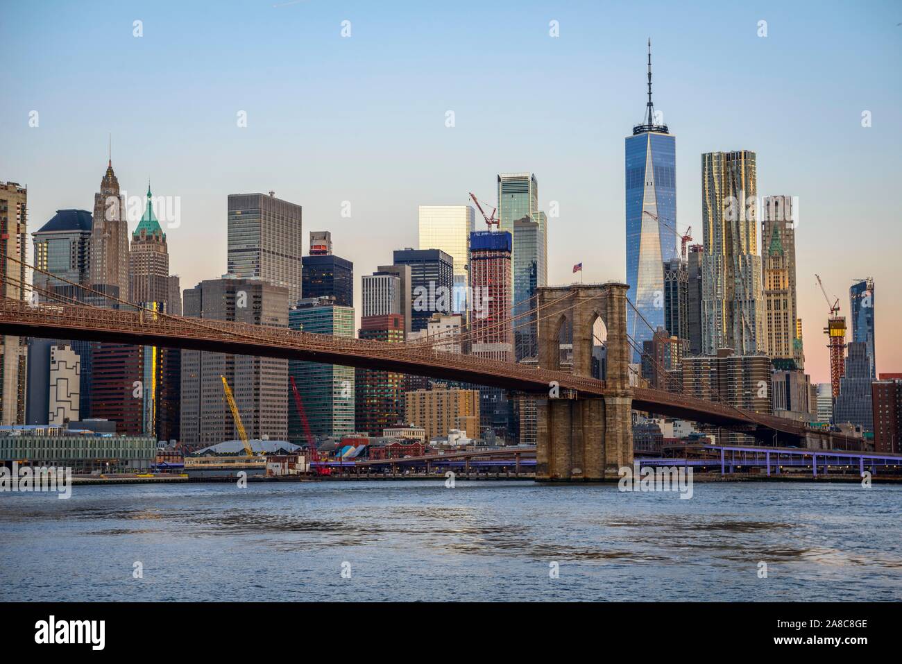 Geht Die Brooklyn Bridge über Den East River Brooklyn Bridge bei Sonnenaufgang, Blick von der Hauptstraße über den