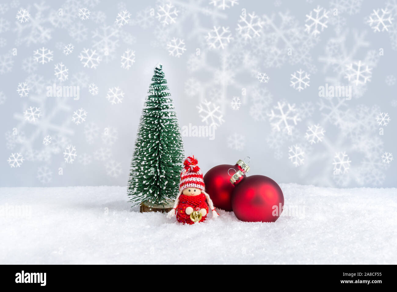 Weihnachten Kind Abbildung in Rot in Form gestrickter Pullover mit Glocke in der Nähe Tanne und Ornamente. Süße Weihnachten Puppe als handgefertigten Weihnachtsschmuck gegen f Stockfoto