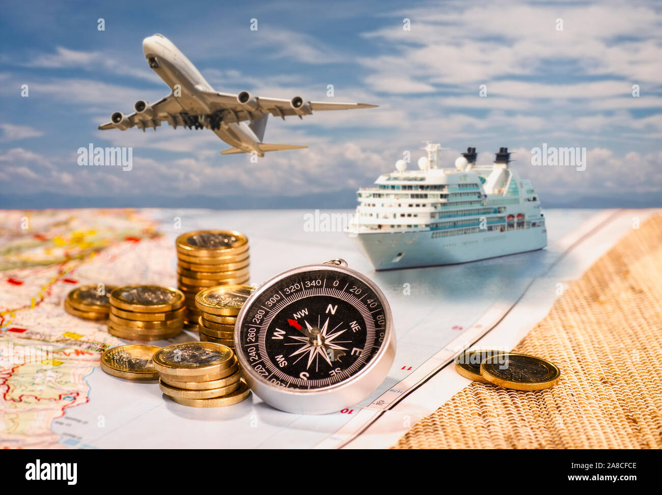 Flugzeug und Schiff mit Kompass und Münzen auf einer Karte Stockfoto