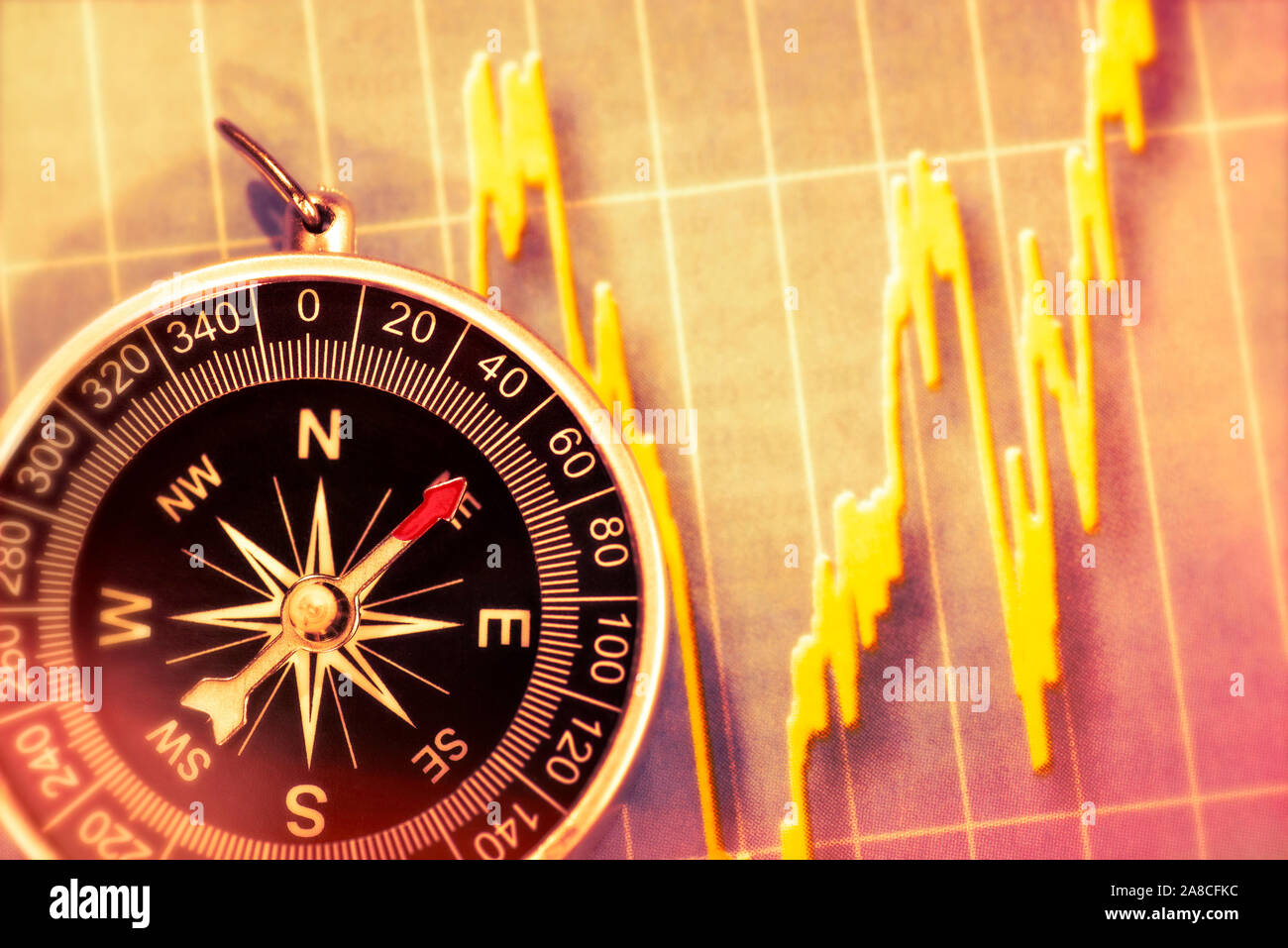 Diagramm mit Börsenkursen und ein Kompass zur Orientierung Stockfoto