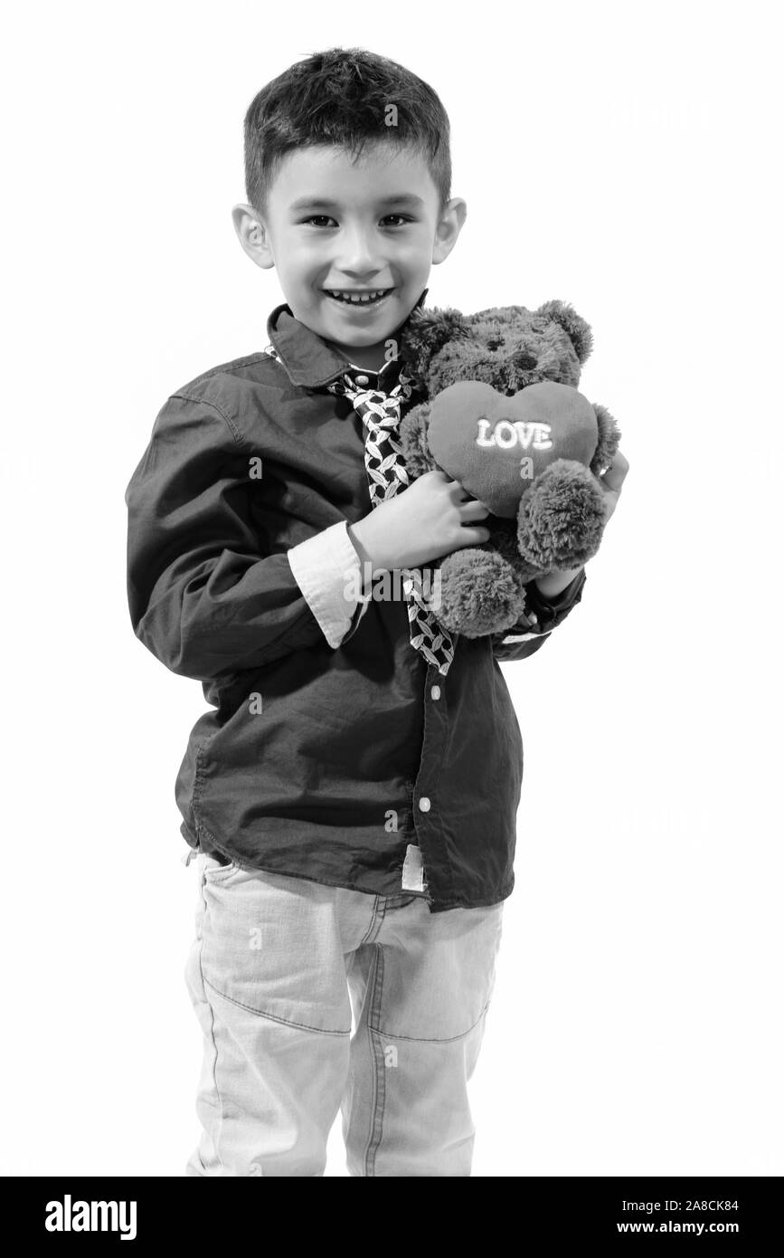 Studio shot von niedlichen Happy Boy und lächelnd Teddybär mit Herz und Liebe Zeichen Stockfoto