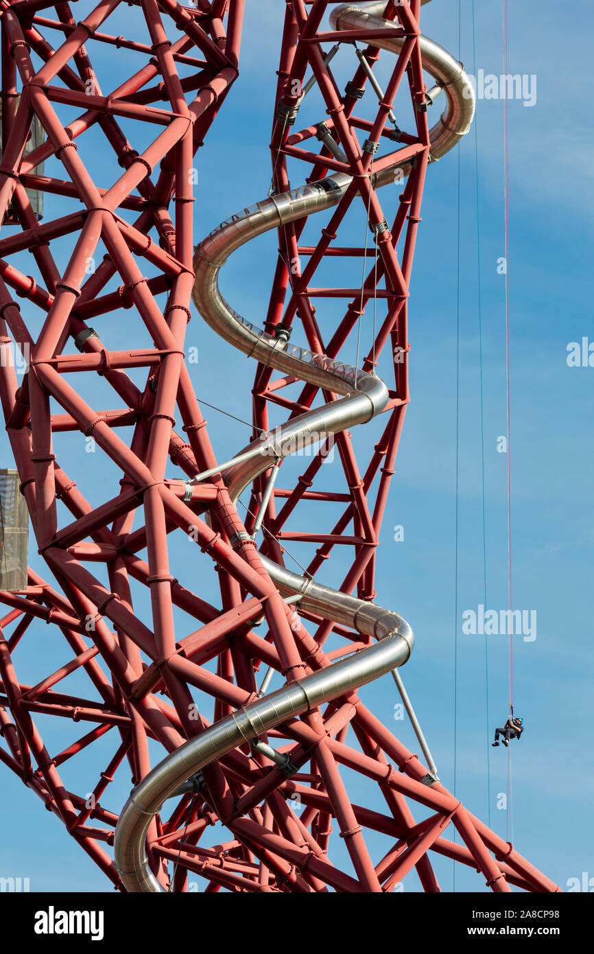 Eine abseiler steigt auf der Unterseite der Folie an der ArcelorMittal Orbit Skulptur in der Queen Elizabeth Olympic Park, Stratford, London, UK. Stockfoto