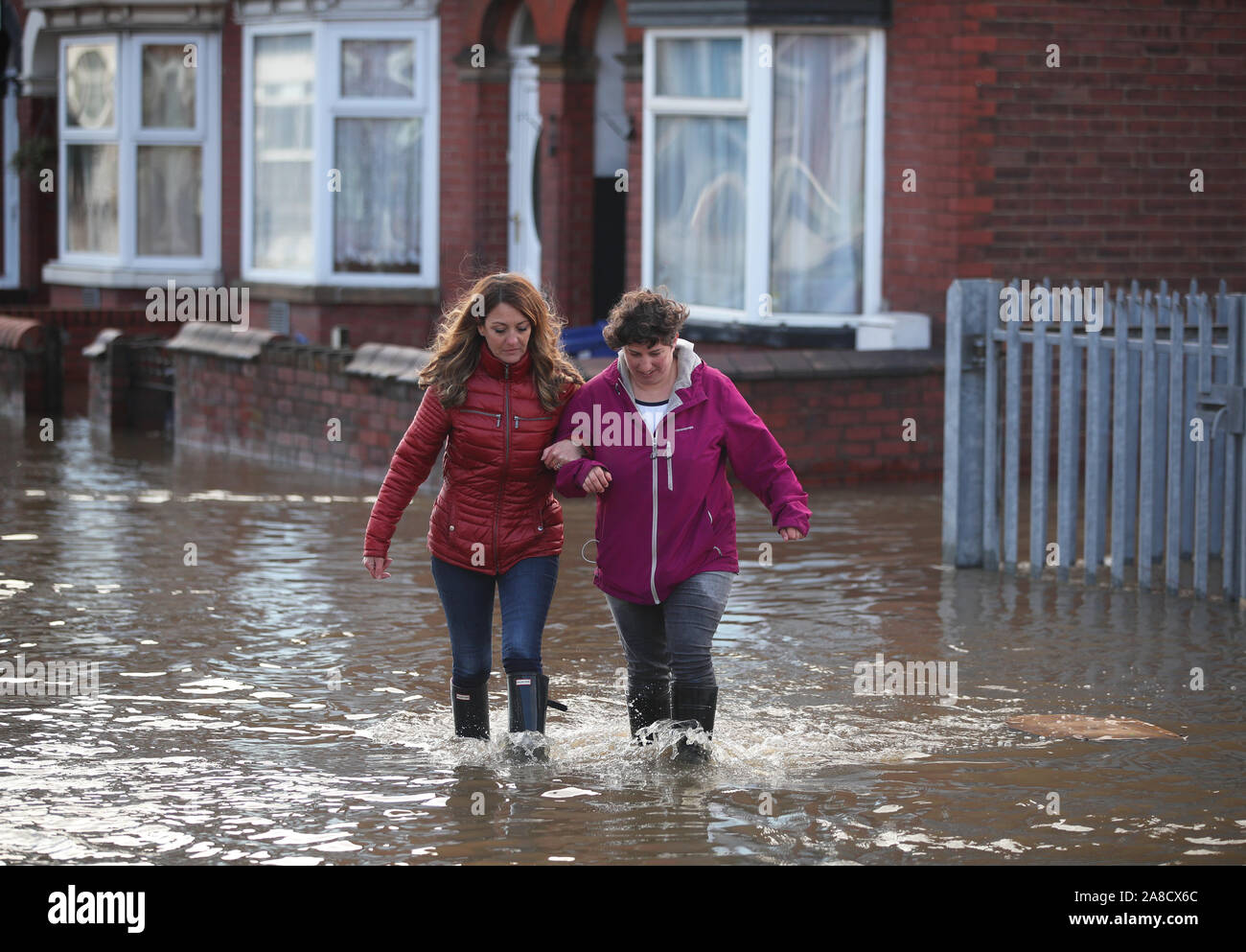 Zwei Menschen laufen durch Hochwasser auf Yarborough Terrasse in Doncaster, Yorkshire, als Teile von England von einem Monat im Wert von Regen in 24 Stunden ausgehalten, mit Kerben von Menschen gerettet oder gezwungen, ihre Häuser zu verlassen, andere über Nacht in einem Einkaufszentrum gestrandet, und Reiseplanung ins Chaos gestürzt. Stockfoto